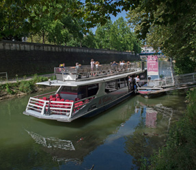 1 a boat floating along a river next to a body of water