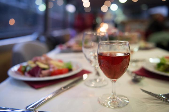 a woman sitting at a table with wine glasses