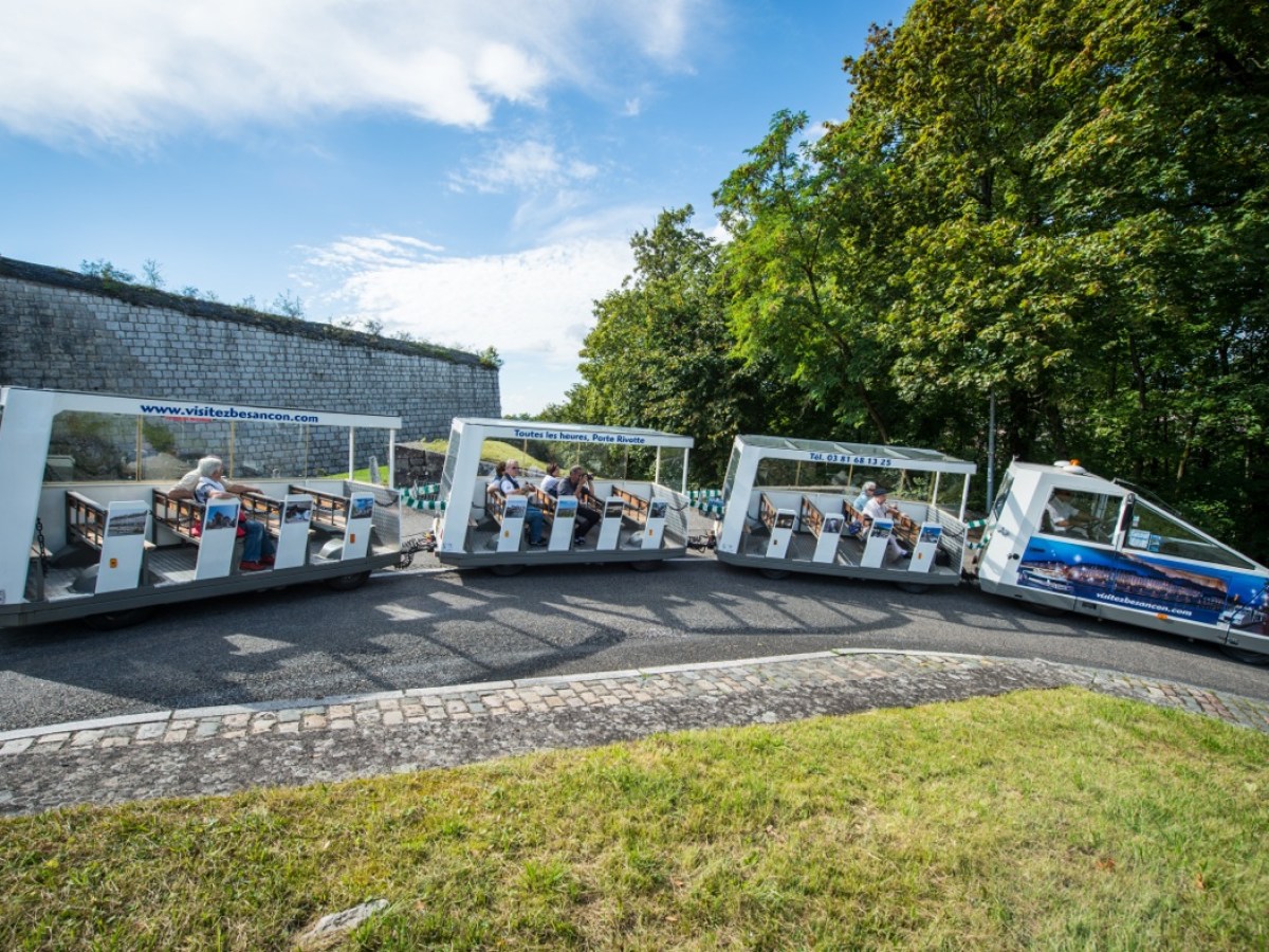 a passenger bus that is parked on the side of a river
