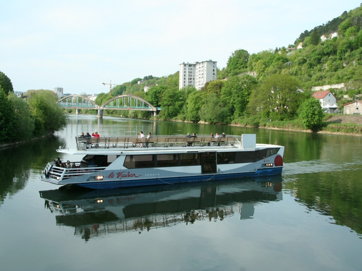 a boat traveling along a river next to a body of water
