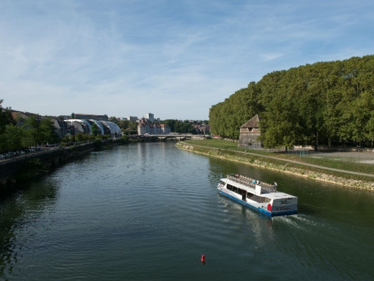 a boat traveling along a river next to a body of water
