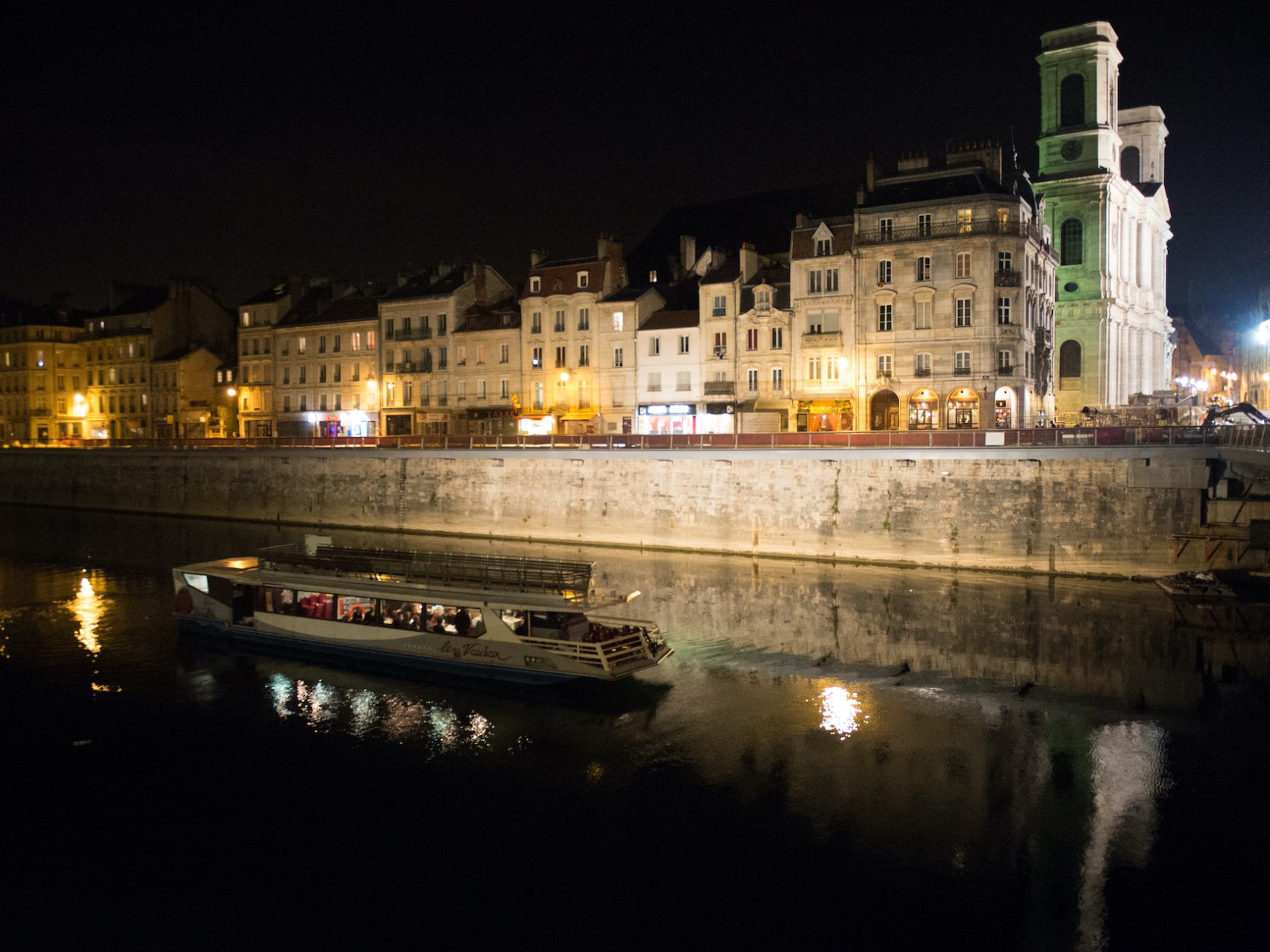 a bridge over a body of water with a city in the background